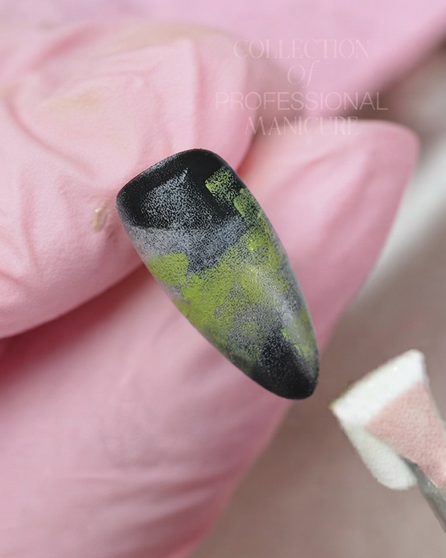 Un pennello fine a punta sottile che applica gel bianco per dipingere un delicato fiore a cinque petali su uno sfondo dunghia sfumato.