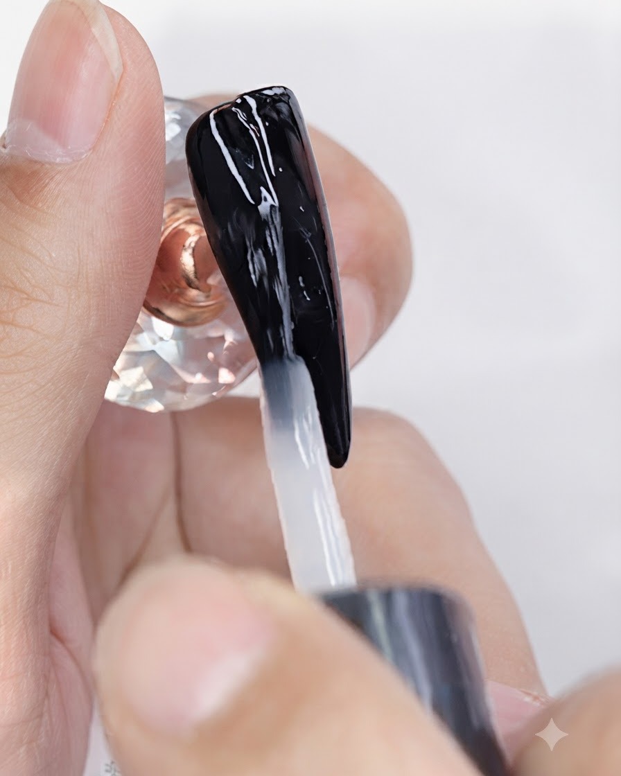 Un pennello applica un top coat gel trasparente opaco su ununghia con smalto gel nero.