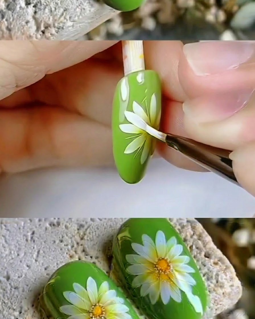 Un pennello per dettagli fine che ritocca i petali bianchi nitidi di un design di nail art a margherita.