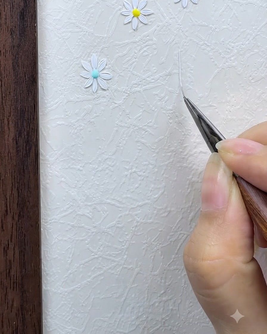 Un pennello liner sottile che disegna una sottile griglia a stella bianca intersecata su una superficie strutturata.