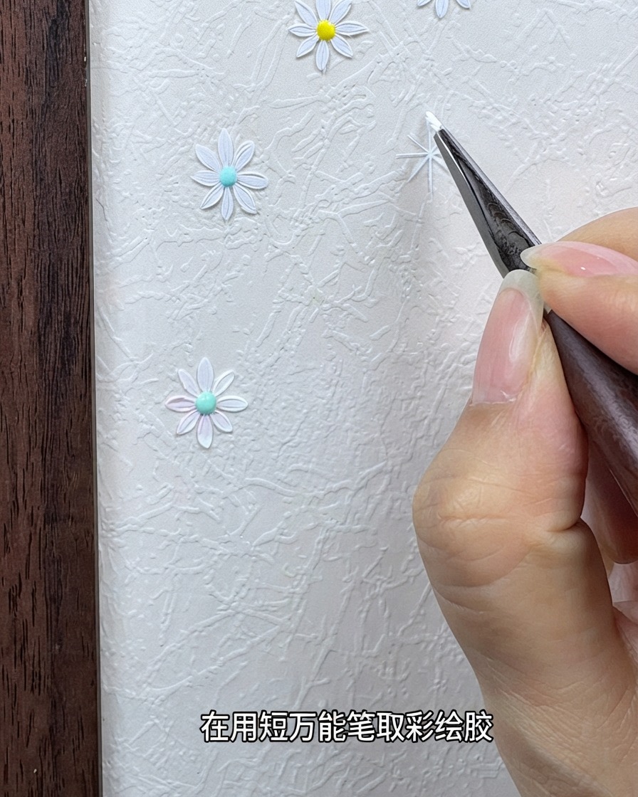 Una mano che regge un pennello da dettaglio fine intriso di gel da pittura bianco vicino a uno sfondo strutturato.