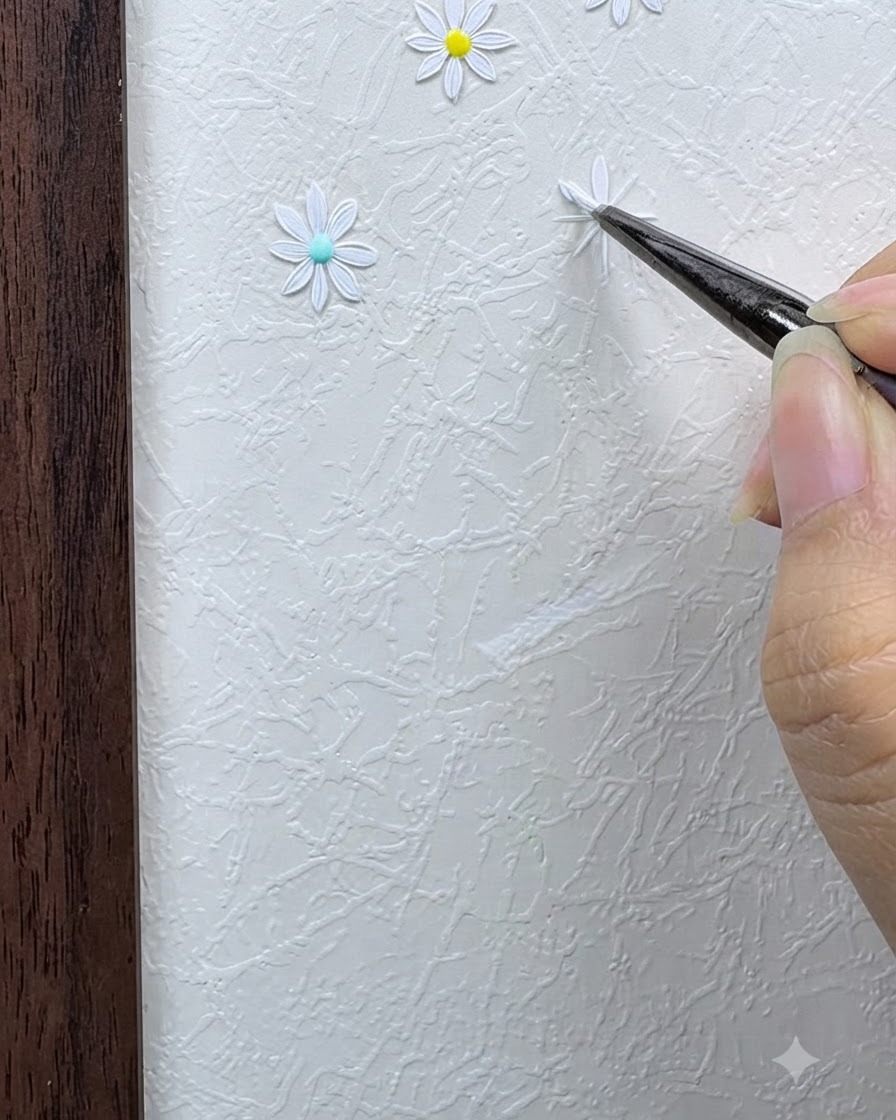 Un pennello fine che applica il primo petalo di margherita bianca usando una tecnica di pressione e rilascio sulla griglia.