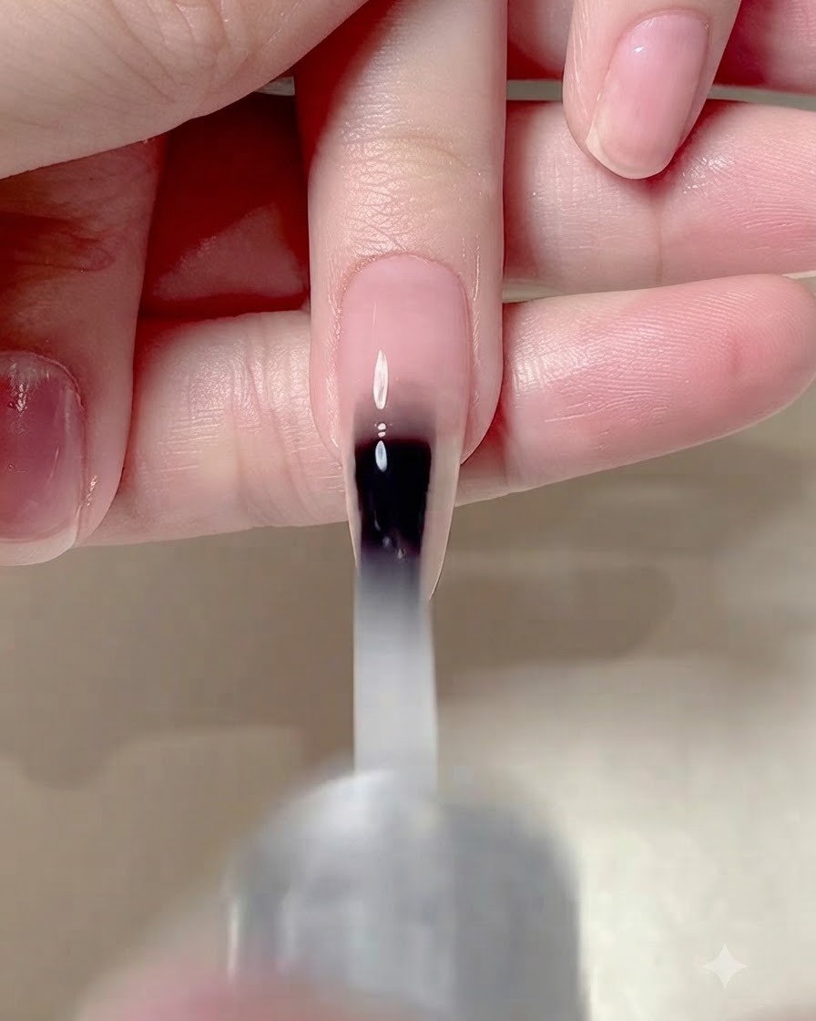 Un pennello da unghie applica un top coat opaco sullintera superficie di ununghia curata.