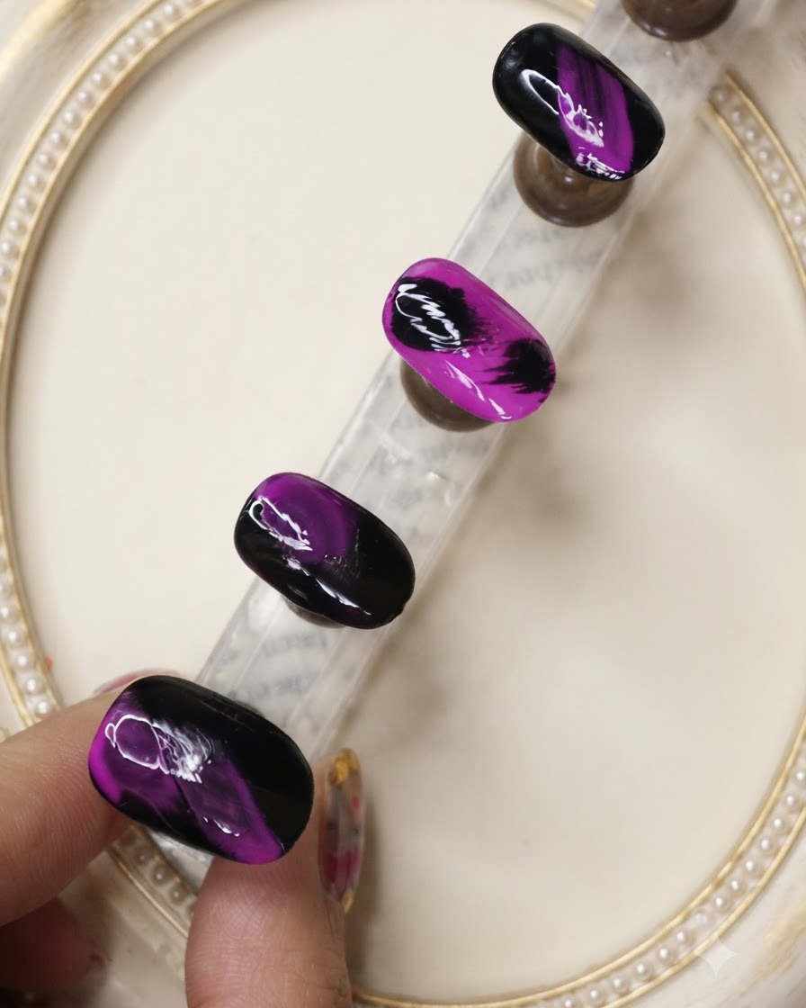 Un pennello per top coat applica uno strato protettivo sui disegni per unghie neri e viola texturizzati.