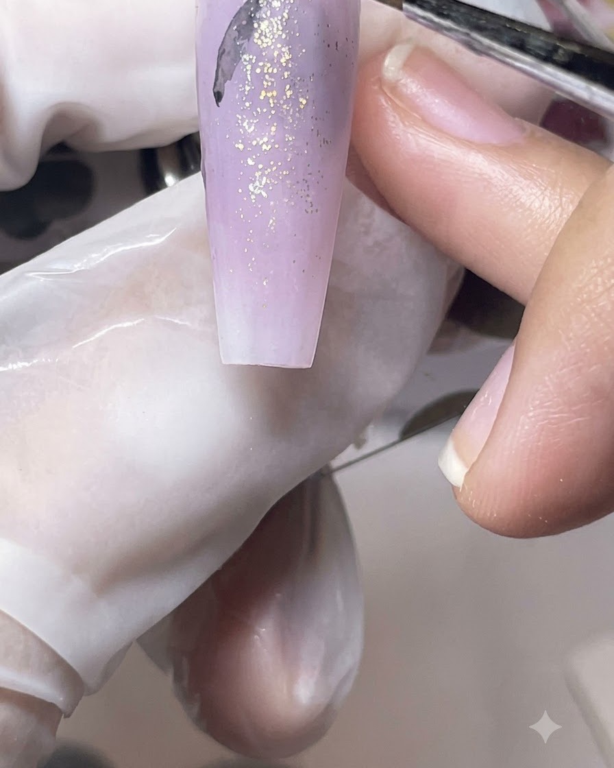 Un pennellino fine che disegna delicate sagome nere di farfalle su una tip opaca viola.