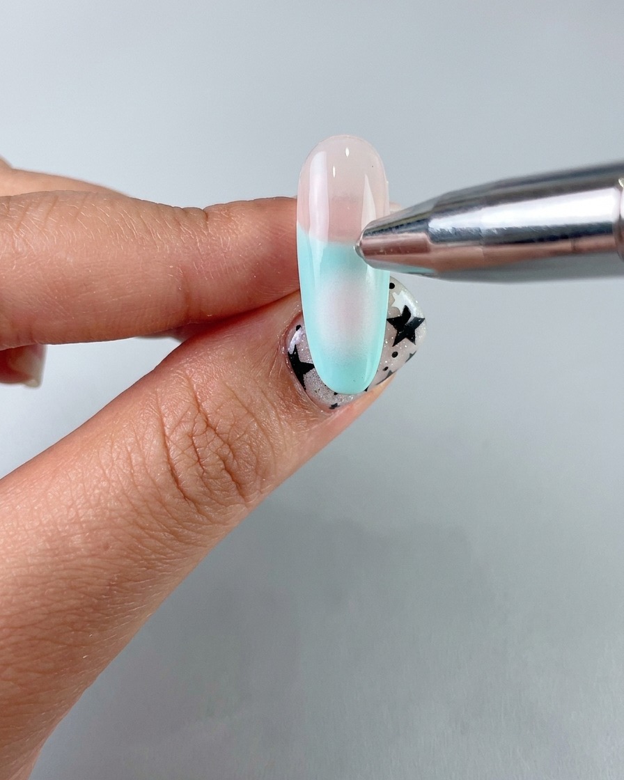 Un applicatore in spugna che applica una morbida sfumatura blush centrale con un gel delicato sullunghia.