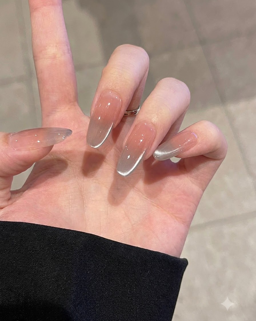 Una mano che utilizza un buffer rosa per opacizzare delicatamente una tip per unghie trasparente.