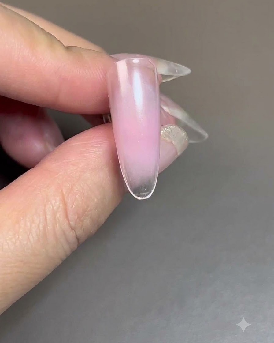 Ununghia con gel blush in fase di polimerizzazione sotto una lampada UV/LED per unghie.
