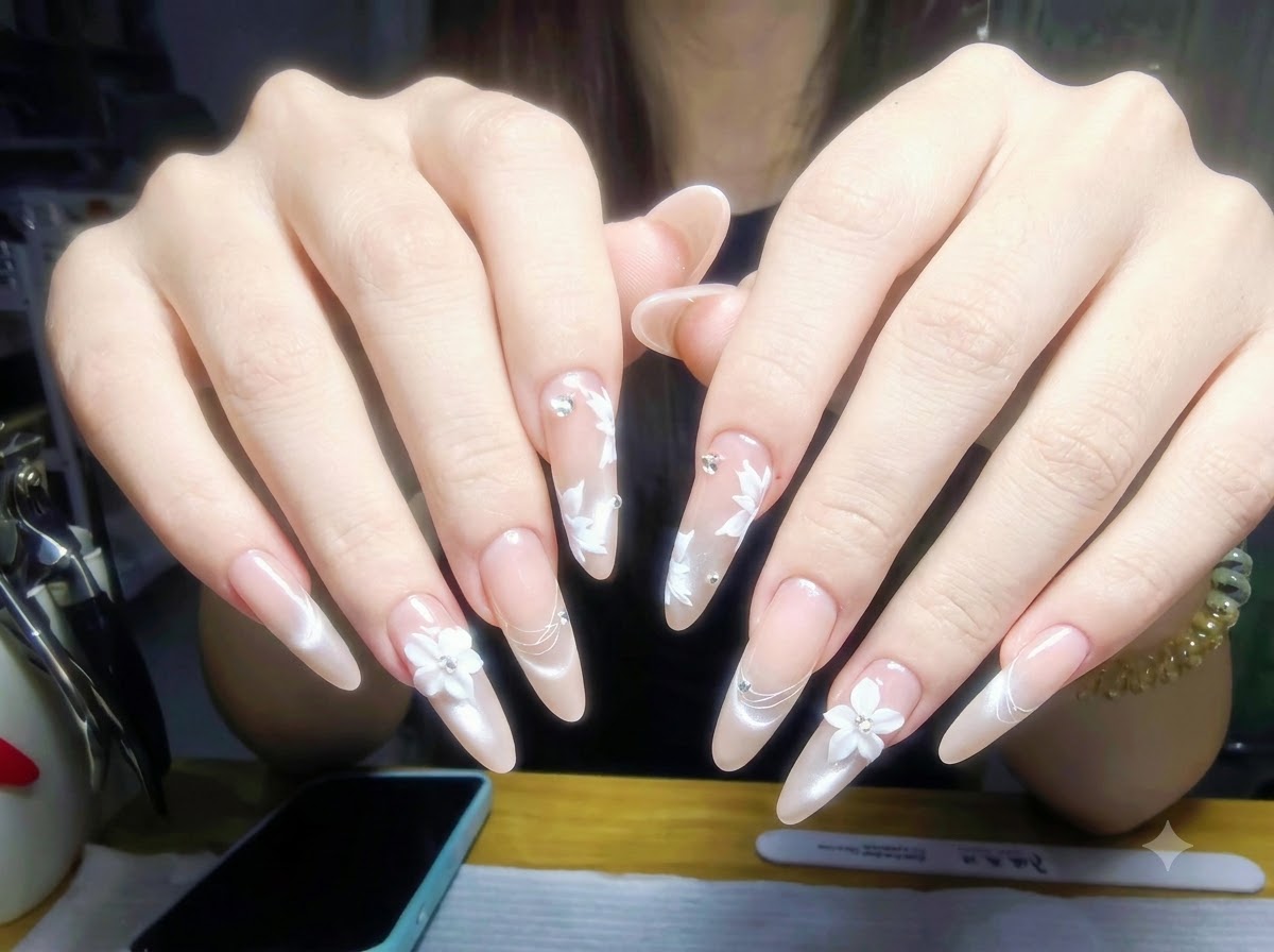 Mani appoggiate su un tavolo da manicure con flaconi di smalto e strumenti professionali disposti ordinatamente sullo sfondo.