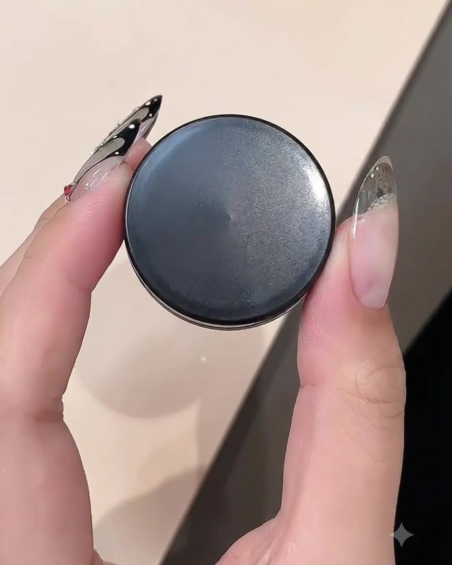 Primo piano di una mano che tiene un barattolo di clay gel mentre lavora sul bordo di ununghia.