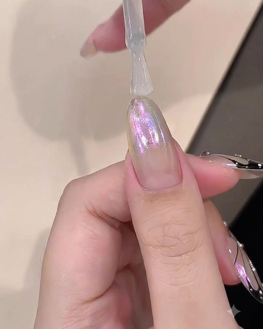 Un pennello che applica uno strato trasparente di builder gel su ununghia con finitura cromata.