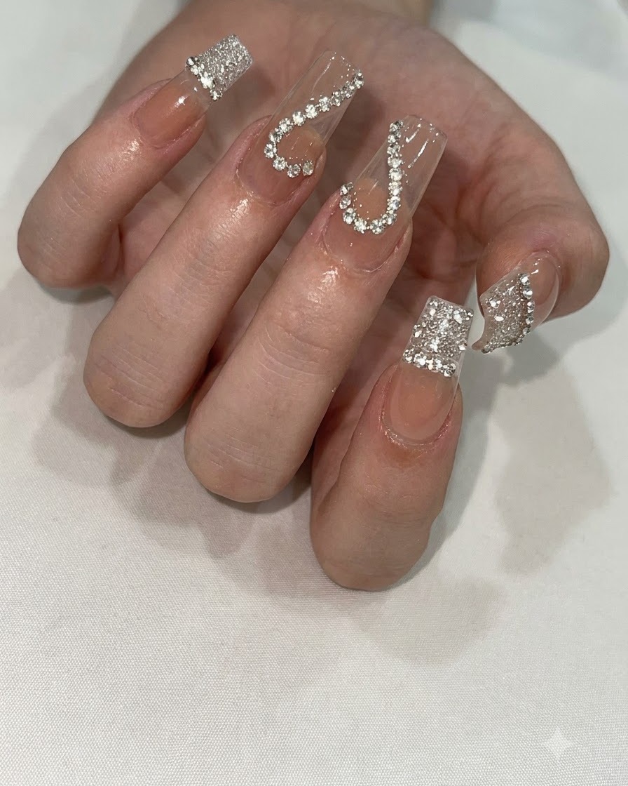 Una mano posizionata sotto una lampada per unghie UV/LED compatta per polimerizzare la nail art dettagliata.