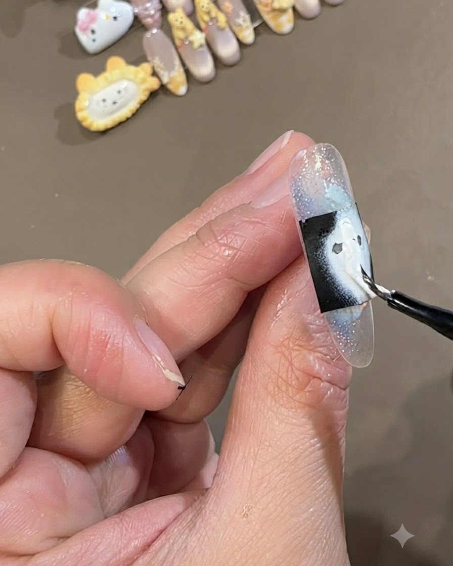 Un pennello fine dipinge uno strato di gel bianco denso sopra uno stencil nero rettangolare posizionato su ununghia incapsulata azzurro ghiaccio.