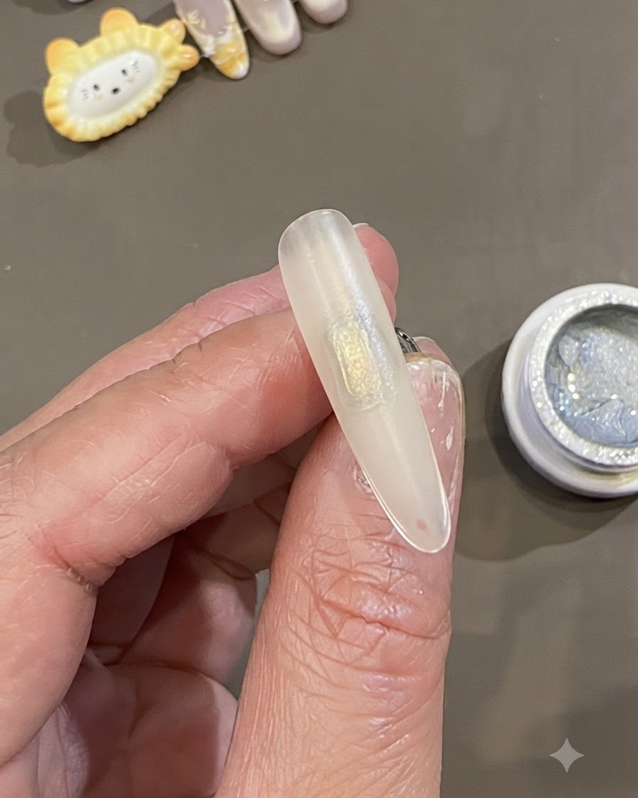 Primo piano di una mano che tiene una punta dunghia smerigliata e preparata con una Toppa rettangolare di gel slip trasparente applicata al centro.