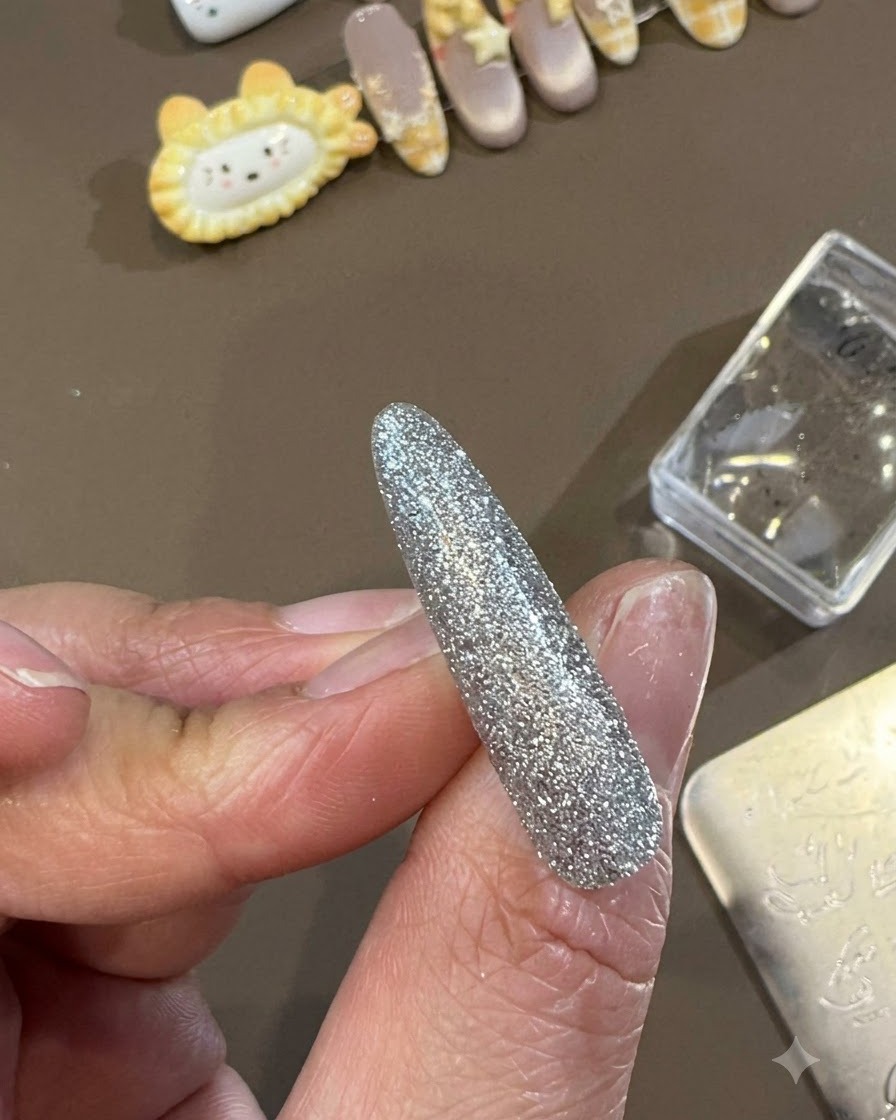 Un pennello per gel top coat che fa scorrere uno strato liscio e lucido di top coat su un design per unghie decorativo completato.