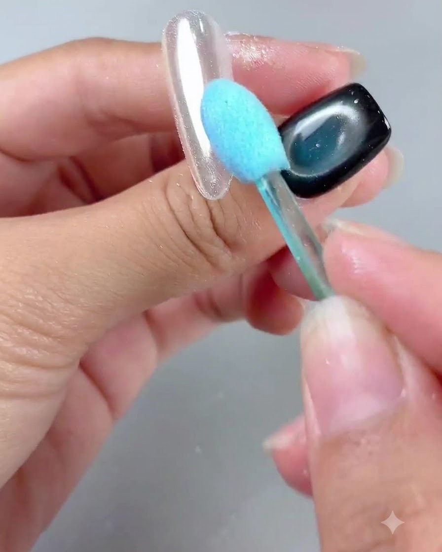 Un pennello con manico blu che rimuove delicatamente la polvere da una tip con finitura a specchio lucida.