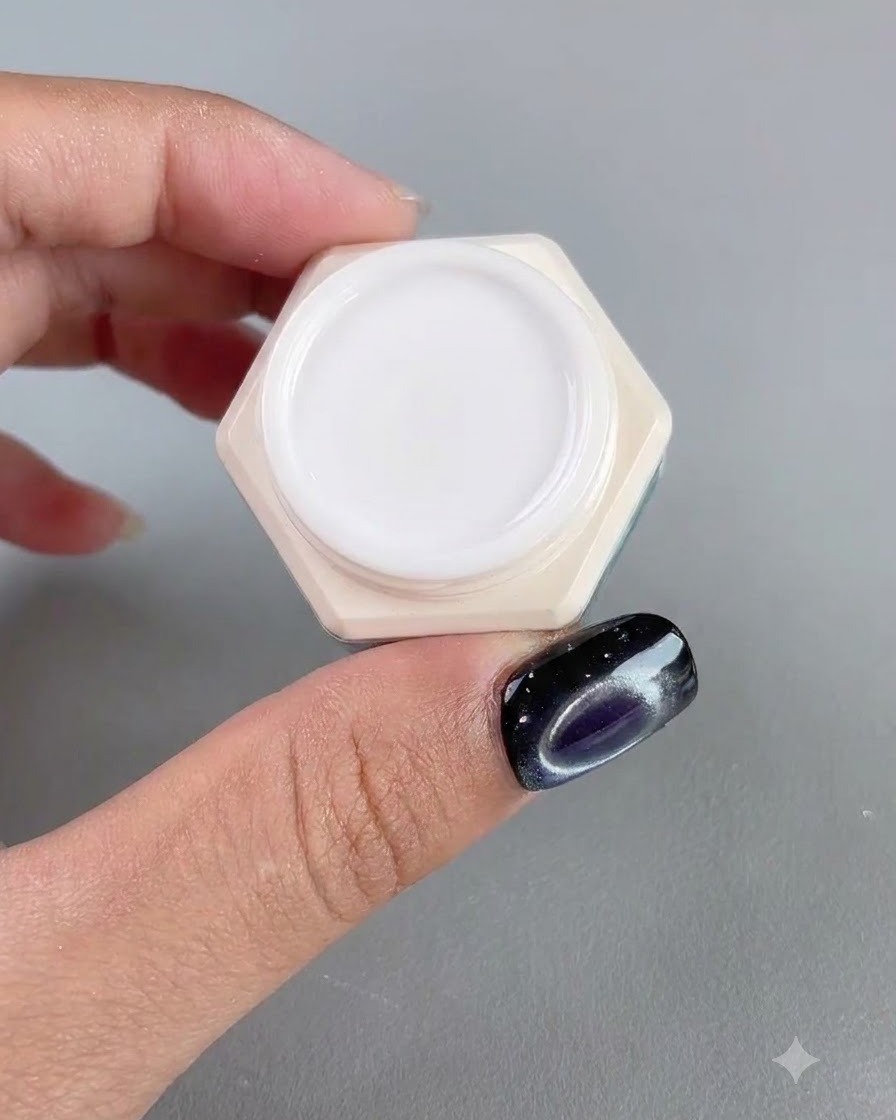Un barattolo di gel per unghie ambra ad alta trasparenza mostrato accanto a un dito con manicure.