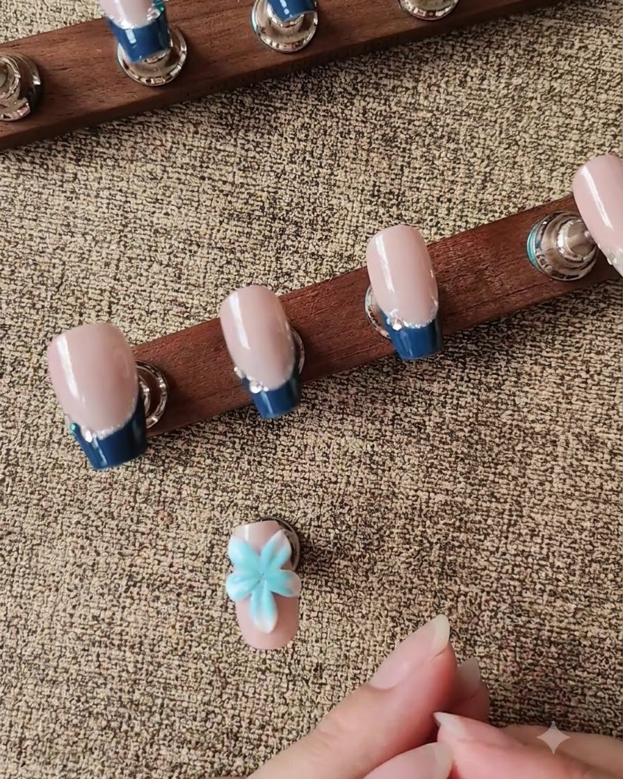 Uno strumento in silicone per modelare che modella un petalo di fiore bianco 3D su ununghia posticcia.