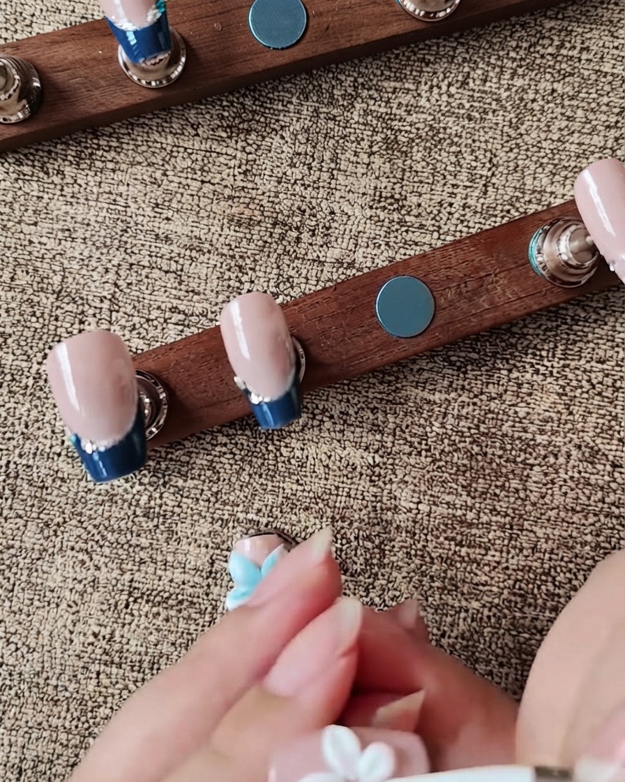 Uno strumento in silicone che modella un petalo di fiore in gel bianco 3D su ununghia posticcia.