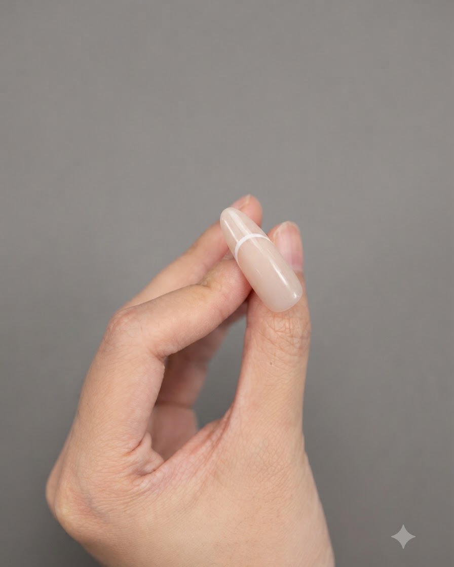 Dita che tengono ununghia a mandorla che mostra un design solido e pulito di french tip bianca.