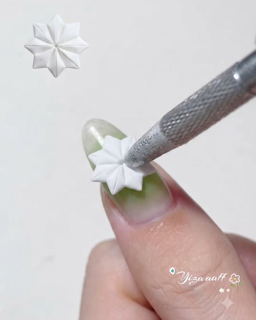 Uno strumento sfuma uniformemente il gel verde traslucido sopra la base argentata cat eye dellunghia.
