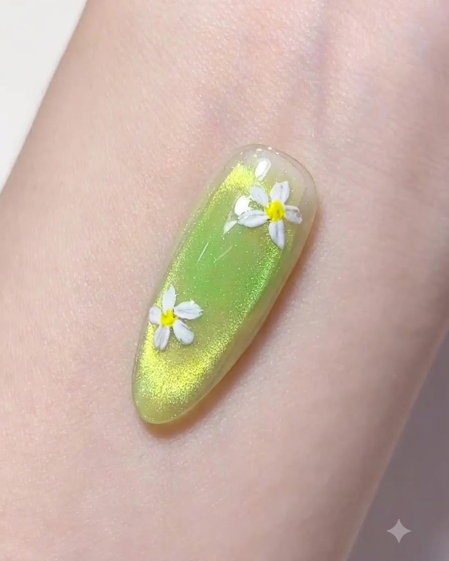 Un pennellino liner sottile raccoglie una goccia di gel costruttore trasparente sopra ununghia curata verde.