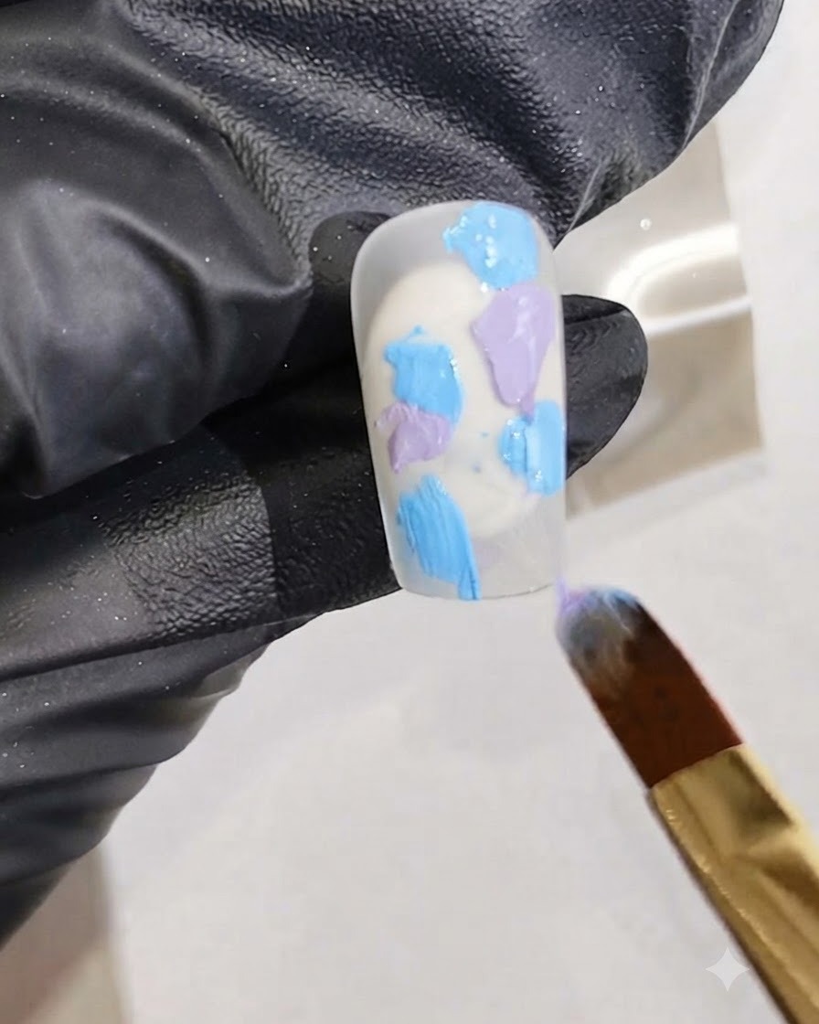 Un pennello fine per nail art che aggiunge striature di smalto gel rosa vivido nella miscela di gel bagnato su ununghia.