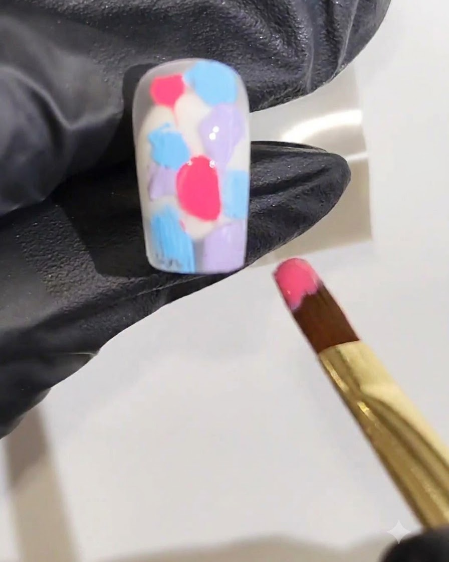Un pennello fine per nail art che posiziona una linea di gel rosso vibrante lungo il centro della superficie dellunghia.