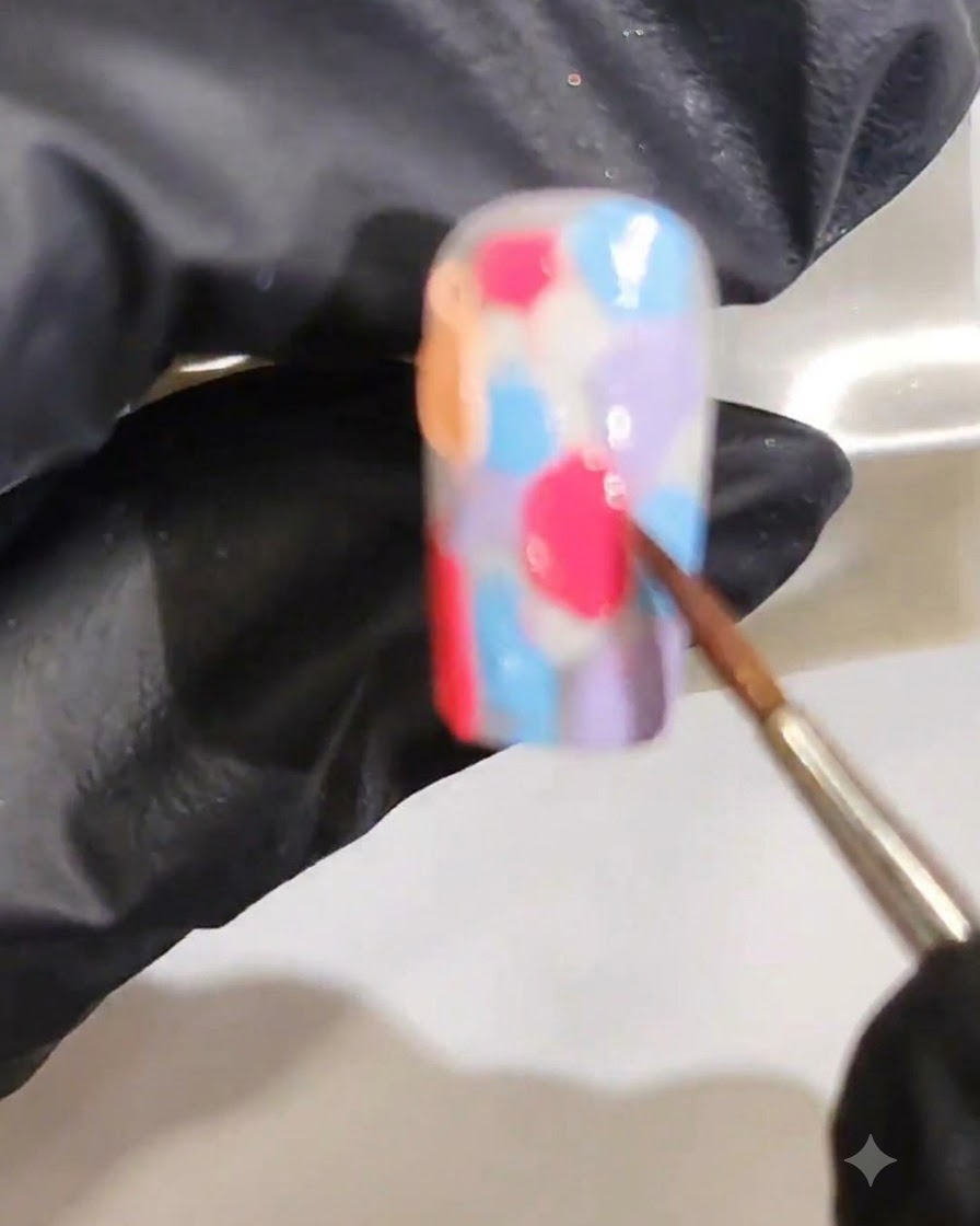 Un pennello fine che sfuma insieme diversi colori di gel bagnato per formare un gradiente acquarello marmorizzato liscio.