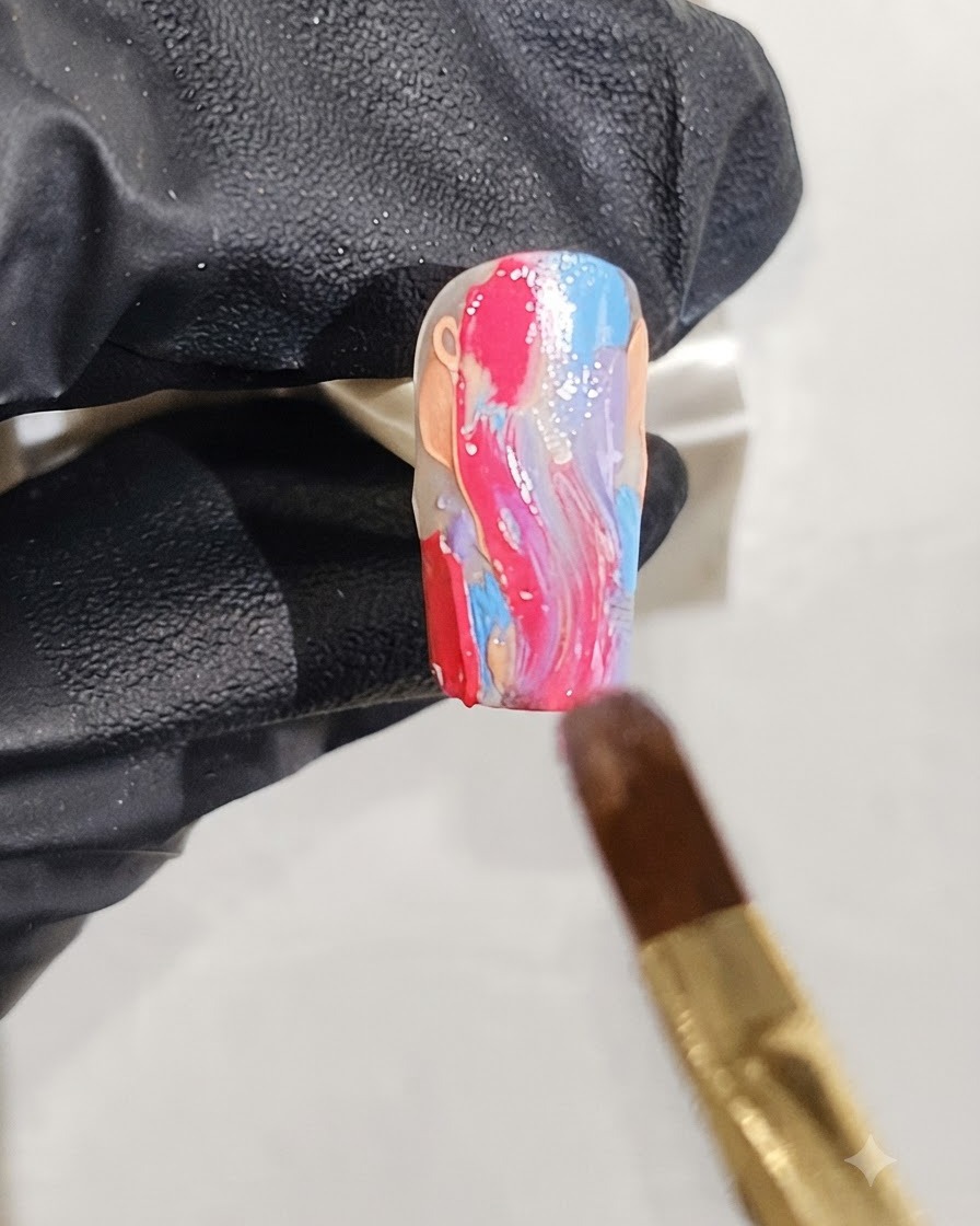 Un pennello fine che applica macchie di glitter argento sparse su un design per unghie in marmo bagnato.
