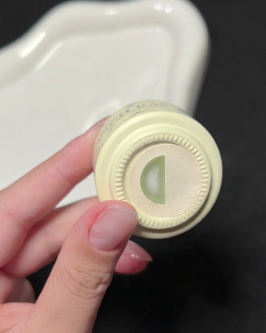 Una mano che tiene una boccetta di smalto gel verde INCH EASY, mostrando letichetta del colore sul tappo.