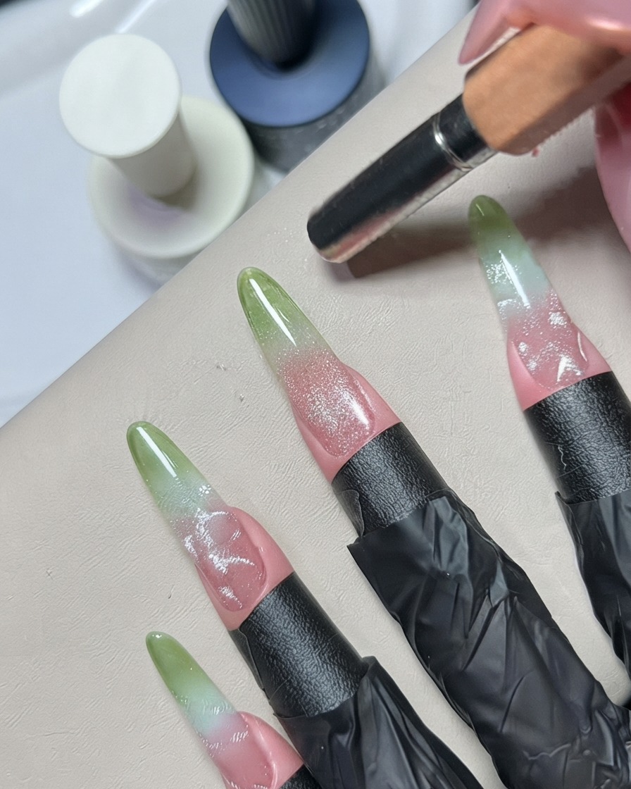 Uno strumento per dotting o un pennello in silicone che sfuma i dettagli in gel argentato su ununghia decorata.