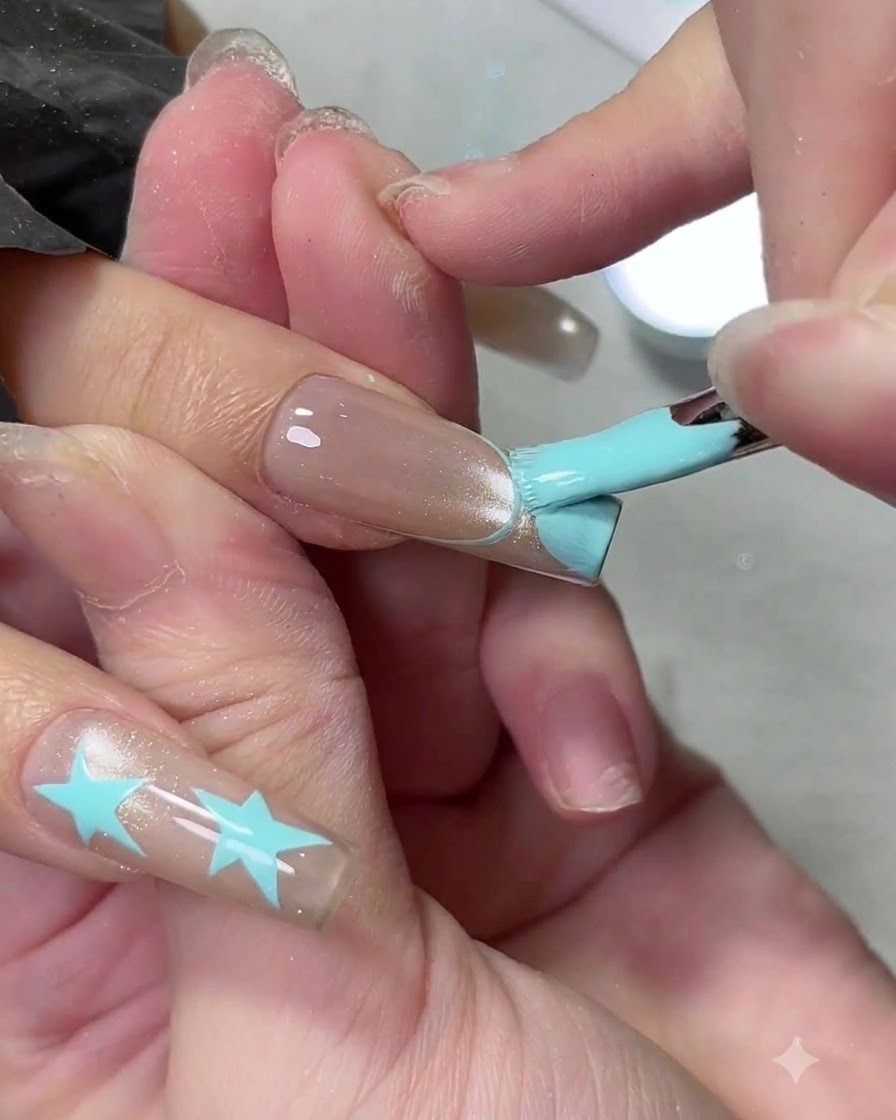 Un pennello da gel piatto riempie la punta di una french manicure azzurra su ununghia lunga.