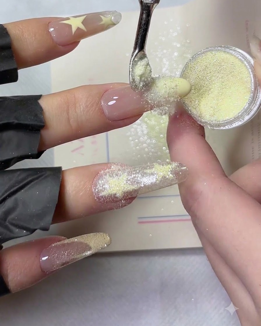 Primo piano della polvere di diamante frantumato gialla sparsa uniformemente su una punta french manicure gialla bagnata.